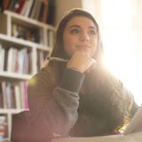 Pensive teenage girl with digital tablet