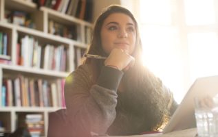 Pensive teenage girl with digital tablet
