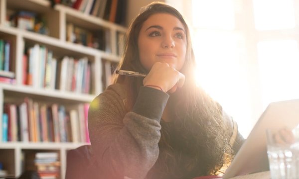 Pensive teenage girl with digital tablet