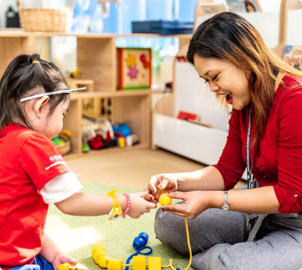 Teacher playing toys with girl